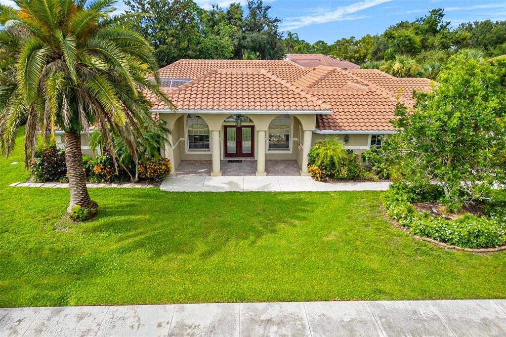 8356 Mareva Lane Sarasota, FL 34241 - Photo 5 of 44 a view of a house with a yard potted plants and a bench