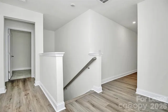 a view of a hallway with wooden floor and staircase