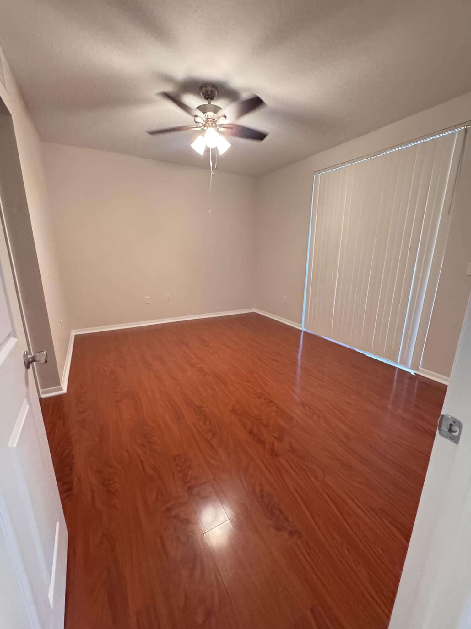 6906 West Sample Road, Unit 6906 Pompano Beach, FL 33063 - Photo 6 of 10 wooden floor in an empty room with a window