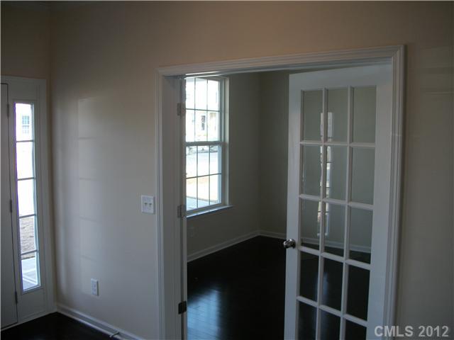 1240 Screech Owl Road Waxhaw, NC 28173 - Photo 3 of 14 an empty room with wooden floor and windows