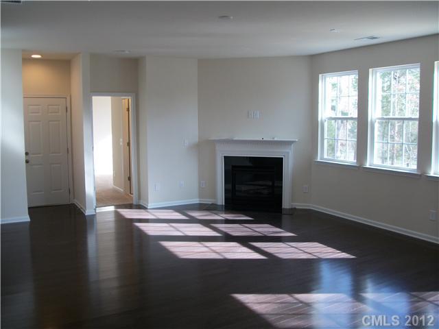 1240 Screech Owl Road Waxhaw, NC 28173 - Photo 5 of 14 a view of an empty room with wooden floor fireplace and a window