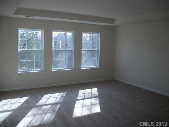 1240 Screech Owl Road Waxhaw, NC 28173 - Photo 6 of 14 an empty room with wooden floor and windows
