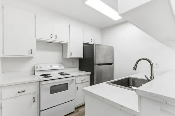 a kitchen with white cabinets and white appliances
