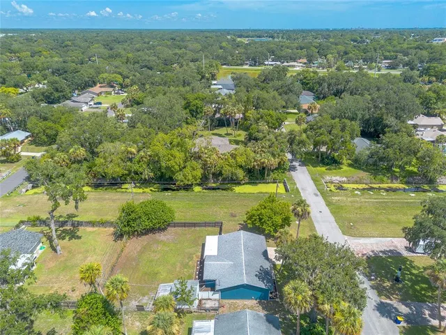 an aerial view of a house with a yard and lake view
