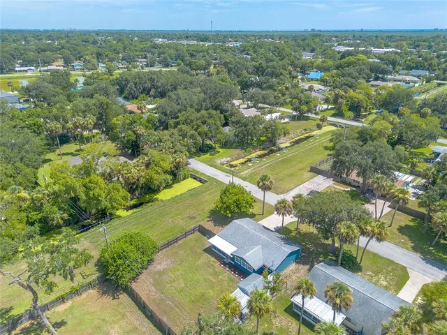 an aerial view of residential houses with outdoor space and trees
