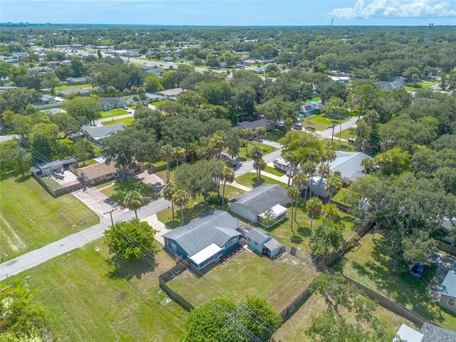 an aerial view of residential houses with outdoor space and trees