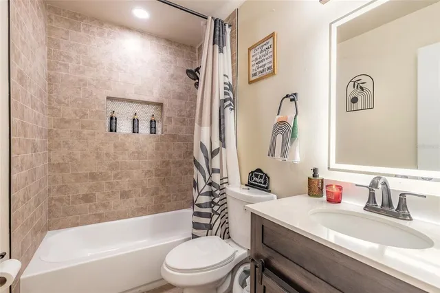 a bathroom with a granite countertop toilet a sink and a bathtub