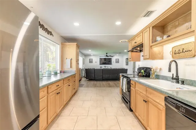 a large kitchen with stainless steel appliances lots of counter space and a sink