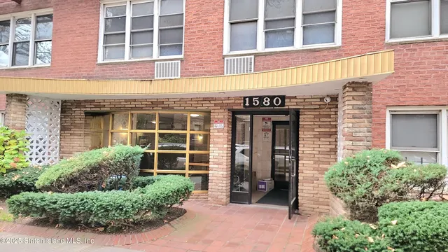 a front view of a building with a garden