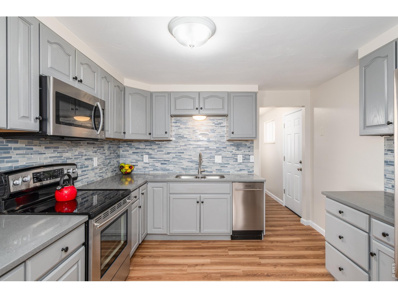 439 Dickson Street Longmont, CO 80504 - Photo 15 of 31 a kitchen with stainless steel appliances granite countertop a sink dishwasher stove top oven and cabinets with wooden floor