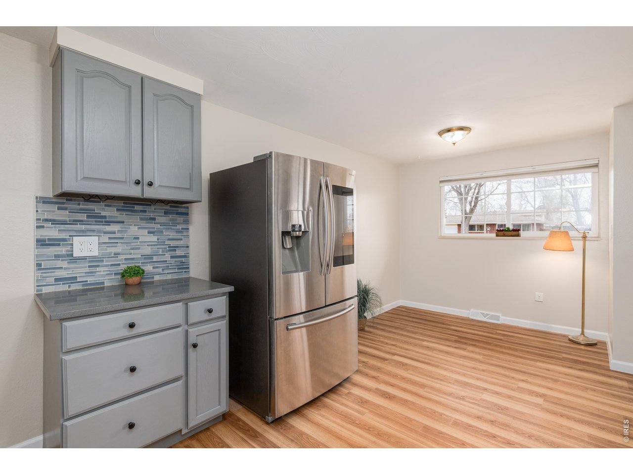 439 Dickson Street Longmont, CO 80504 - Photo 18 of 31 a kitchen with a refrigerator and a wooden floor