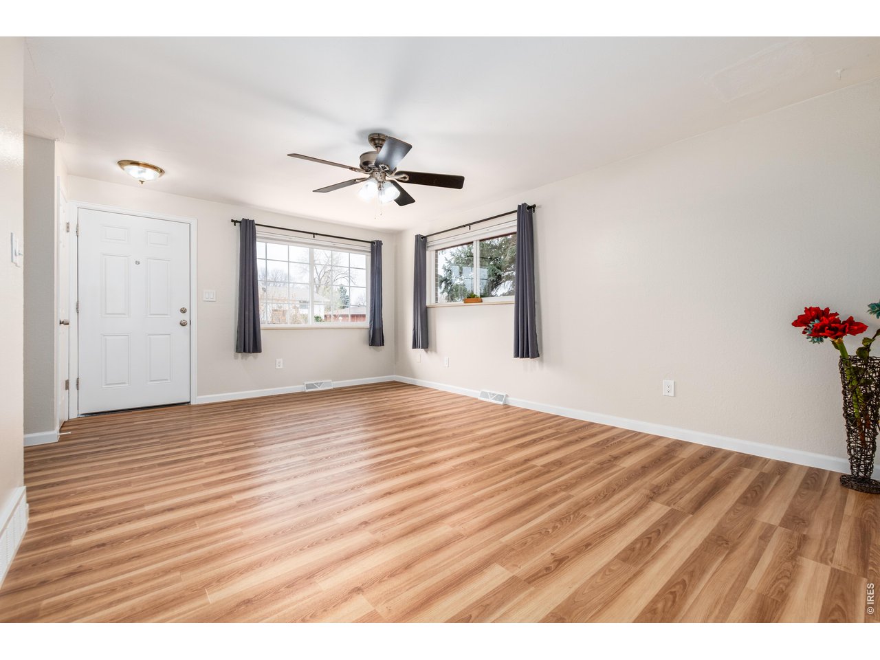 439 Dickson Street Longmont, CO 80504 - Photo 4 of 31 a view of an empty room with a window and wooden floor