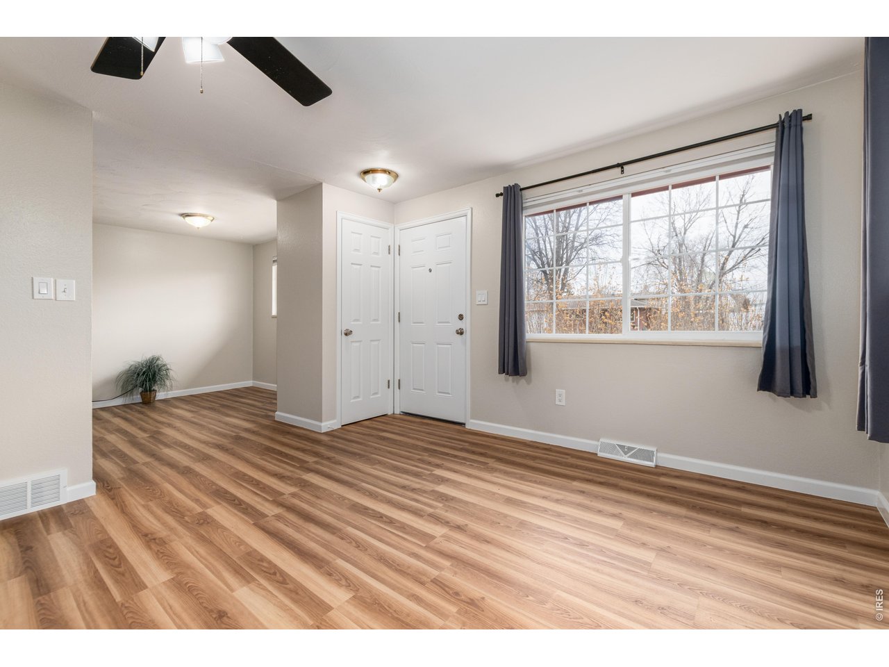 439 Dickson Street Longmont, CO 80504 - Photo 7 of 31 a view of empty room with wooden floor and windows