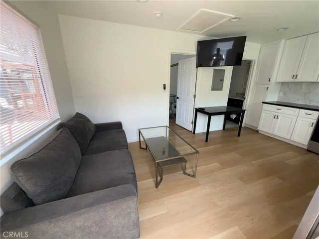 a living room with furniture a flat screen tv and a window