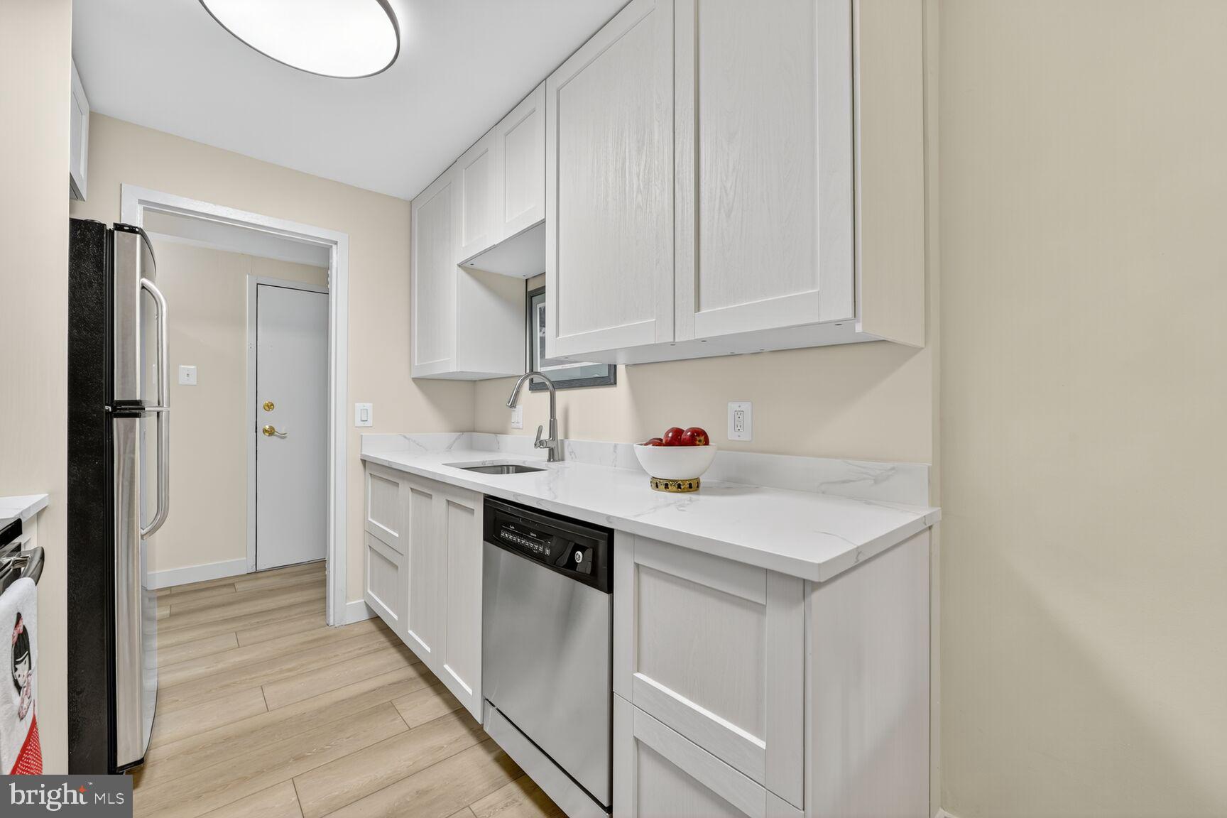 2208 Castle Rock Square, Unit 2B Reston, VA 20191 - Photo 13 of 51 a kitchen with stainless steel appliances granite countertop a sink and dishwasher with white cabinets