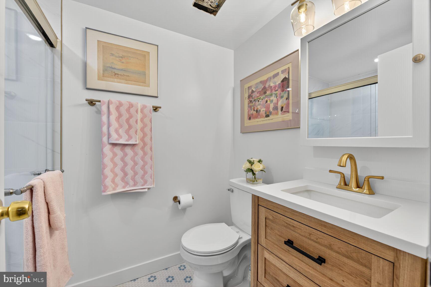 2208 Castle Rock Square, Unit 2B Reston, VA 20191 - Photo 19 of 51 a bathroom with a toilet sink and mirror
