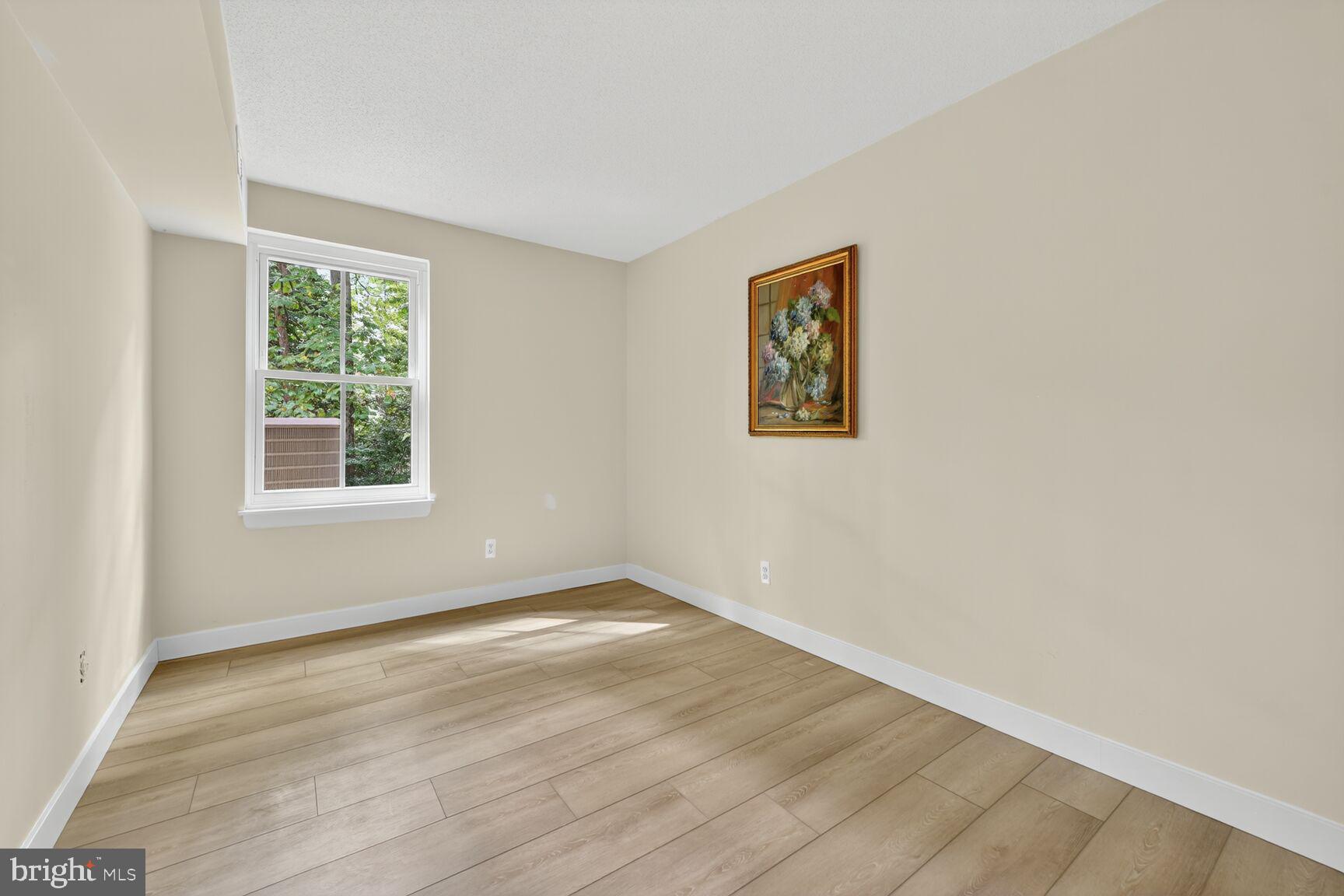 2208 Castle Rock Square, Unit 2B Reston, VA 20191 - Photo 21 of 51 a view of an empty room with wooden floor and a window