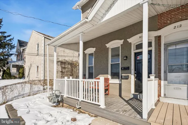 a porch with a bench next to a yard