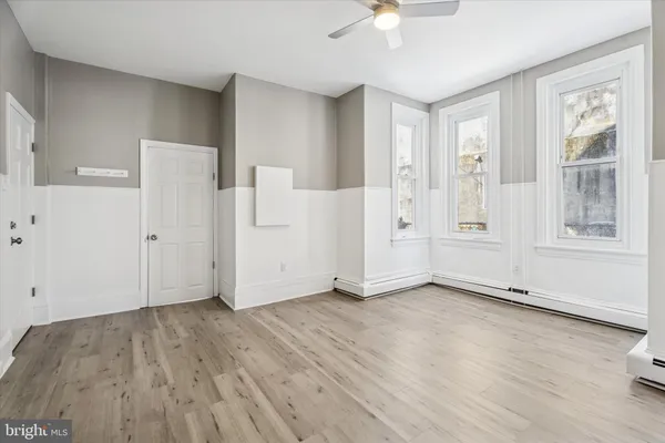 an empty room with wooden floor and windows