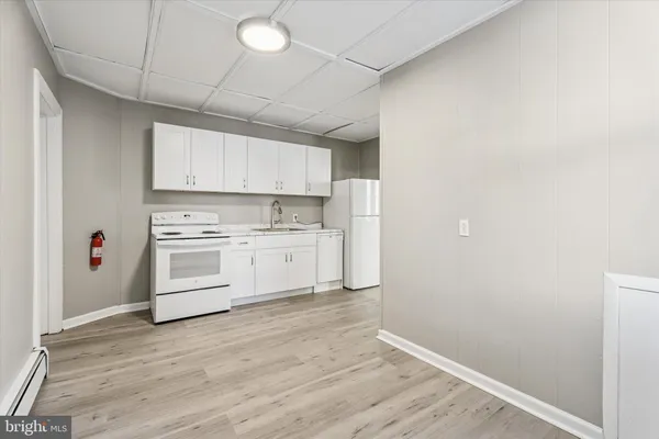 a kitchen with white cabinets and white appliances