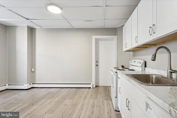 a view of a kitchen with sink and dishwasher with wooden floor
