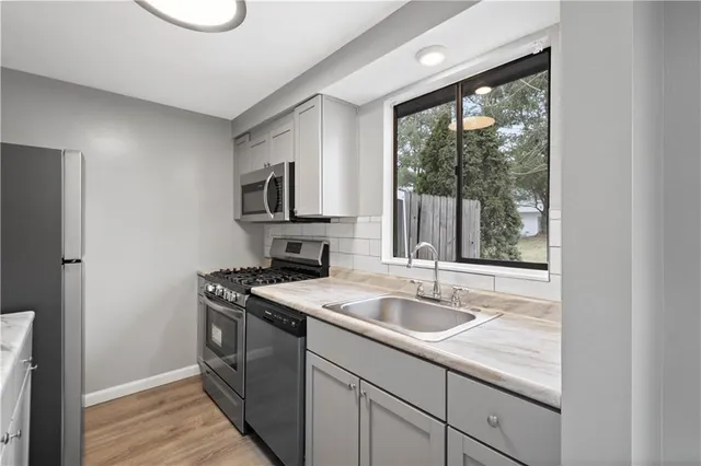 a kitchen with a sink stove and microwave