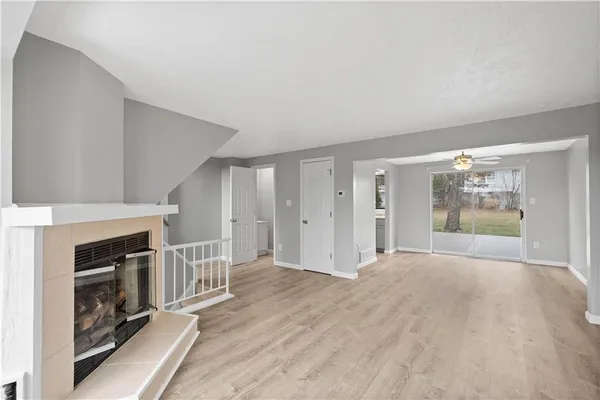 a view of an empty room with a fireplace and a window