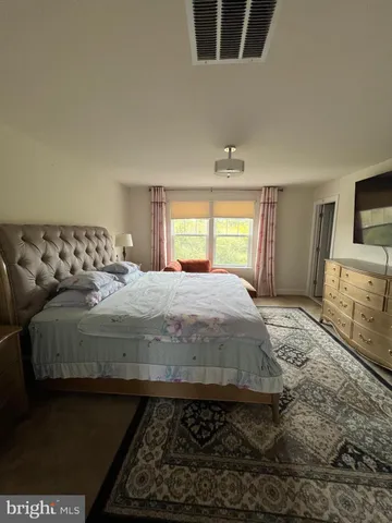 a bedroom with a large bed and a tv