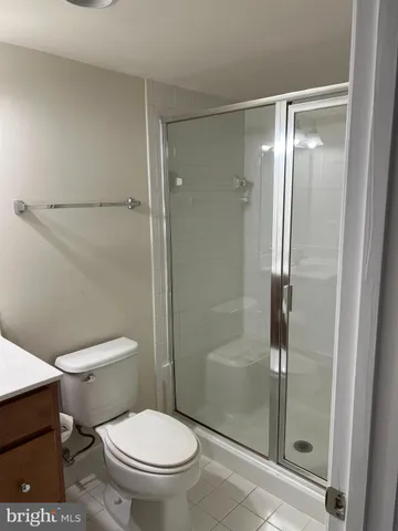 a white toilet next to a glass door
