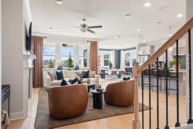 a living room with furniture kitchen view and a chandelier