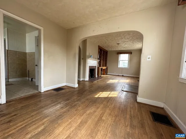 a view of empty room with wooden floor