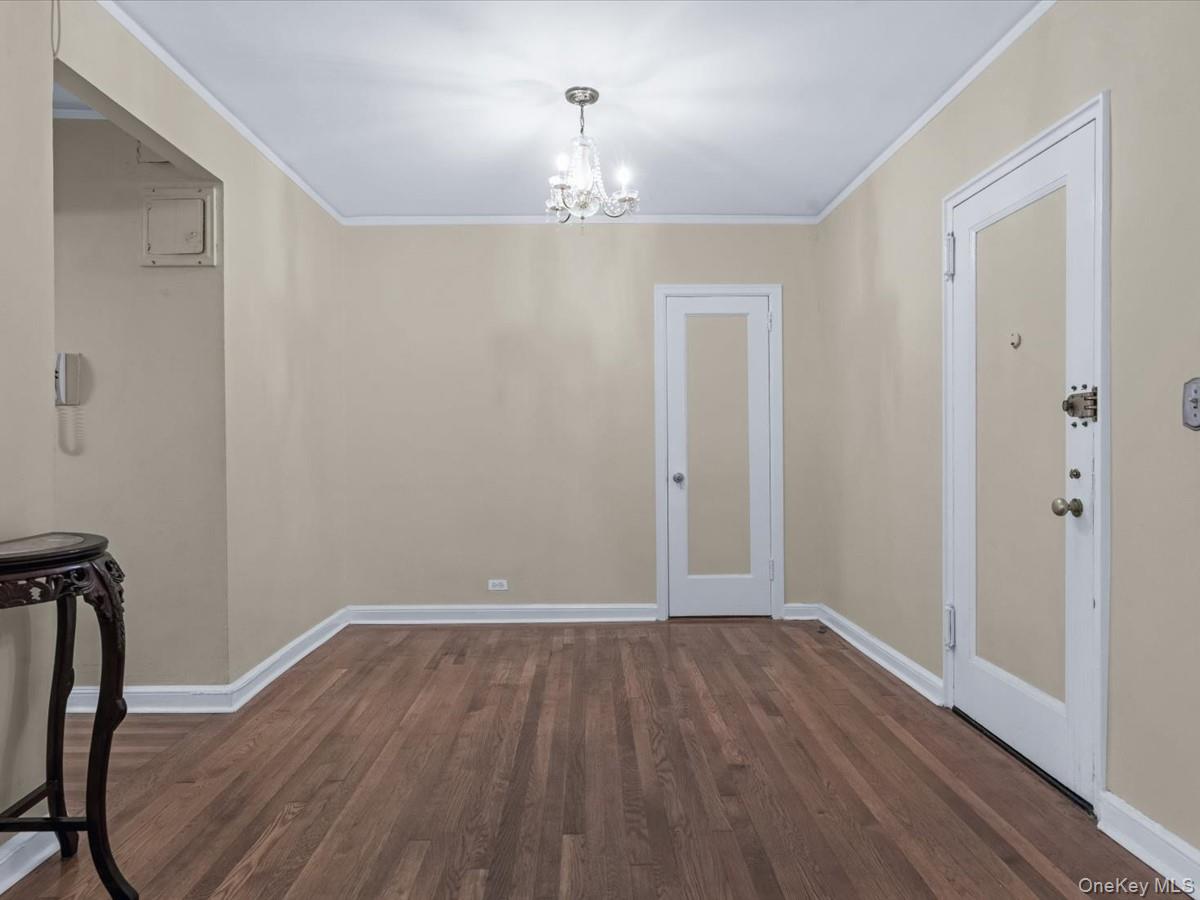 11034 73rd Road, Unit 4F Queens, NY 11375 - Photo 5 of 24 a view of a hallway with wooden floor and chandelier