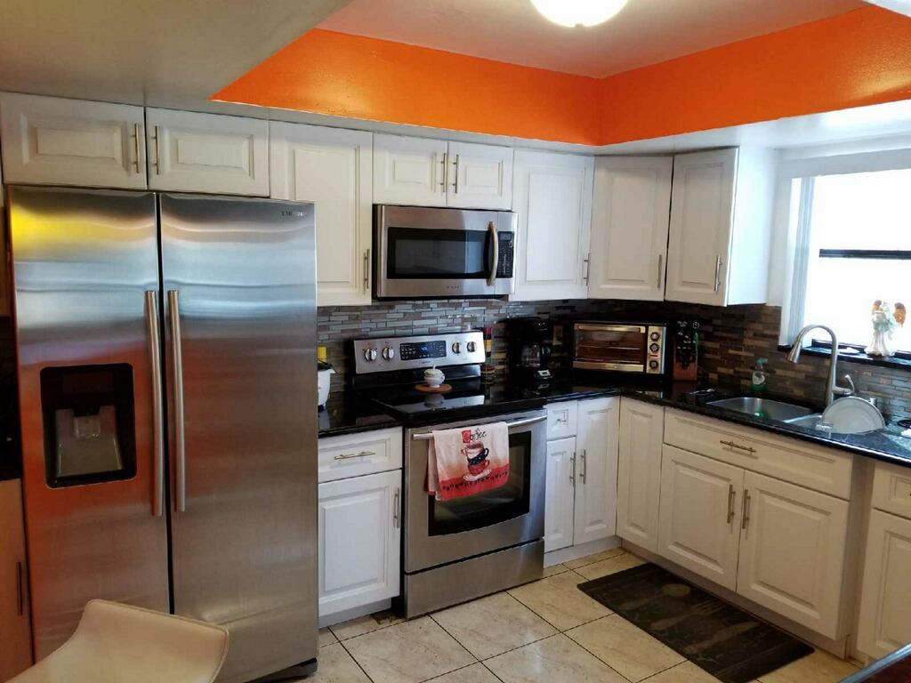 3768 Mil-Stream Court Greenacres, FL 33463 - Photo 1 of 36 a kitchen with stainless steel appliances granite countertop a refrigerator a sink and white cabinets