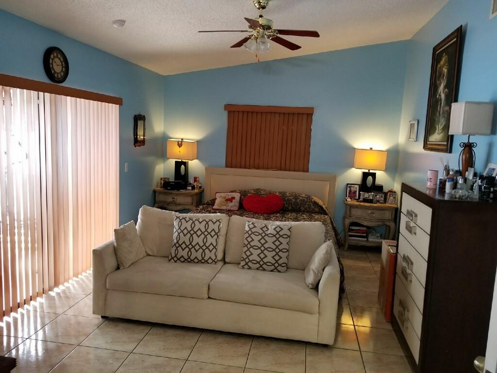 3768 Mil-Stream Court Greenacres, FL 33463 - Photo 15 of 36 a living room with furniture a lamp and a window