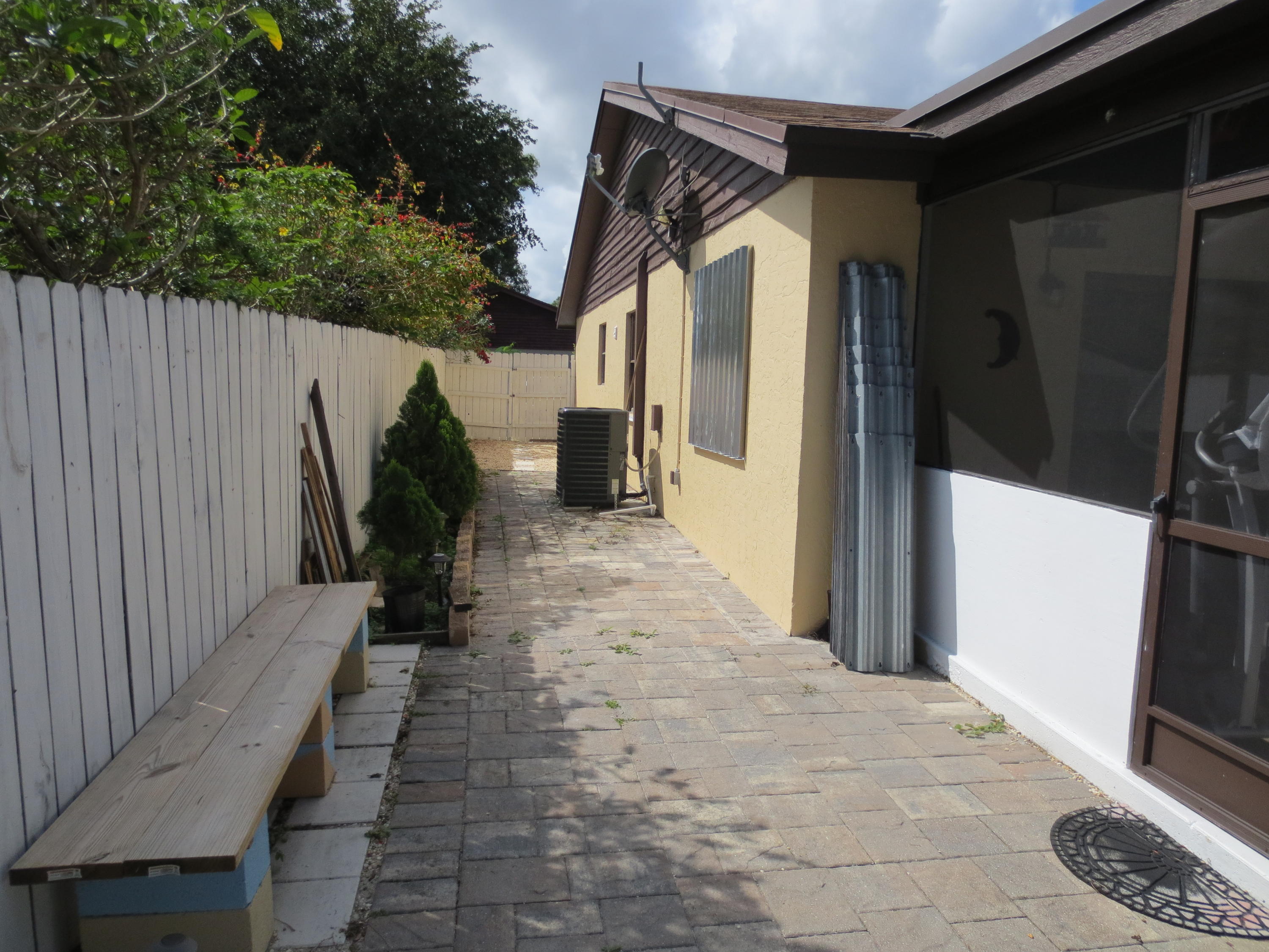 3768 Mil-Stream Court Greenacres, FL 33463 - Photo 18 of 36 a view of a pathway of a house with backyard and wooden fence