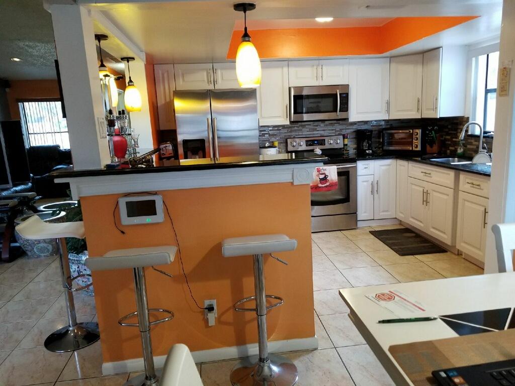 3768 Mil-Stream Court Greenacres, FL 33463 - Photo 2 of 36 a kitchen with stainless steel appliances granite countertop a stove a sink and a microwave