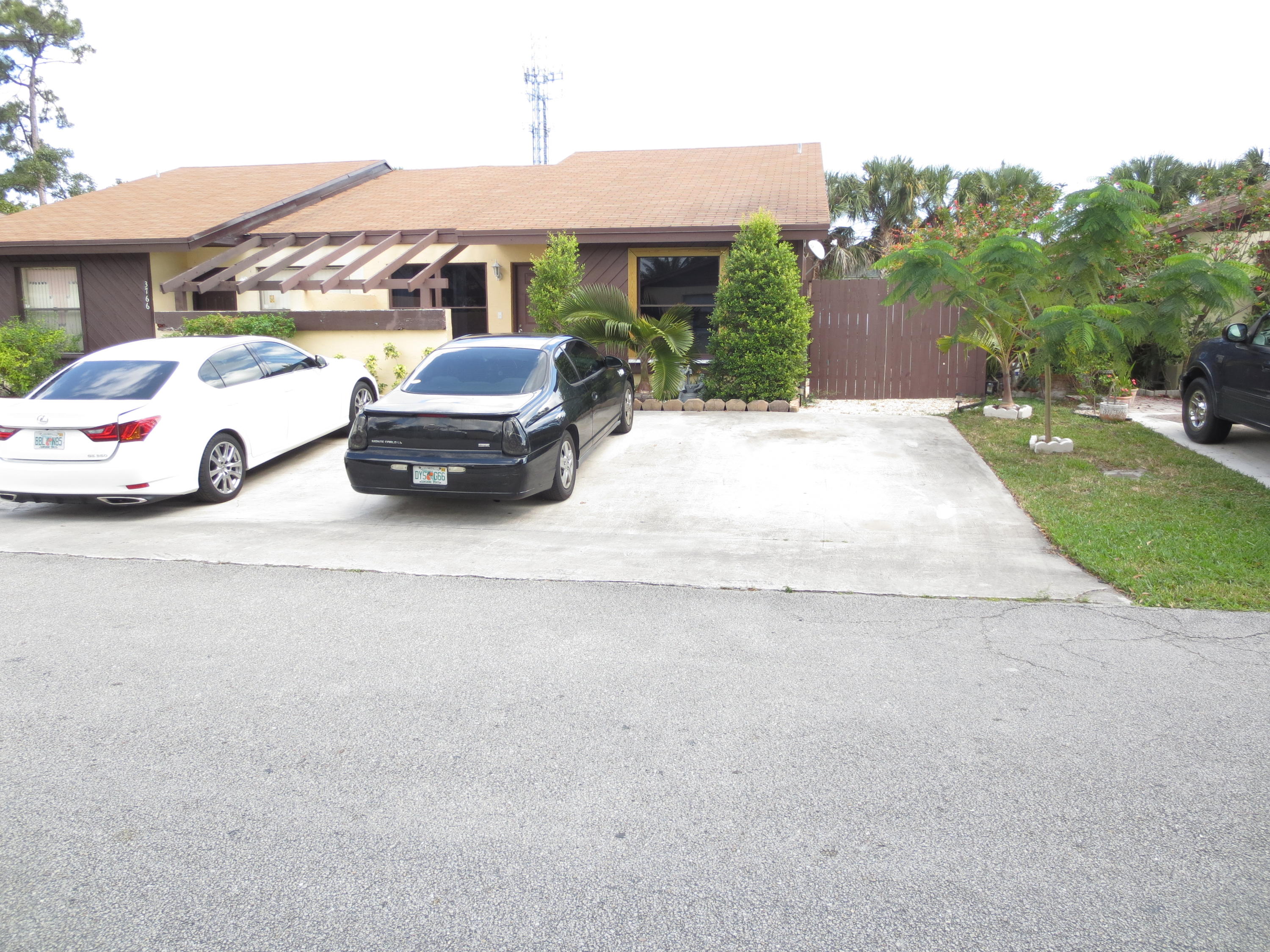 3768 Mil-Stream Court Greenacres, FL 33463 - Photo 31 of 36 a car parked in front of a house with a yard