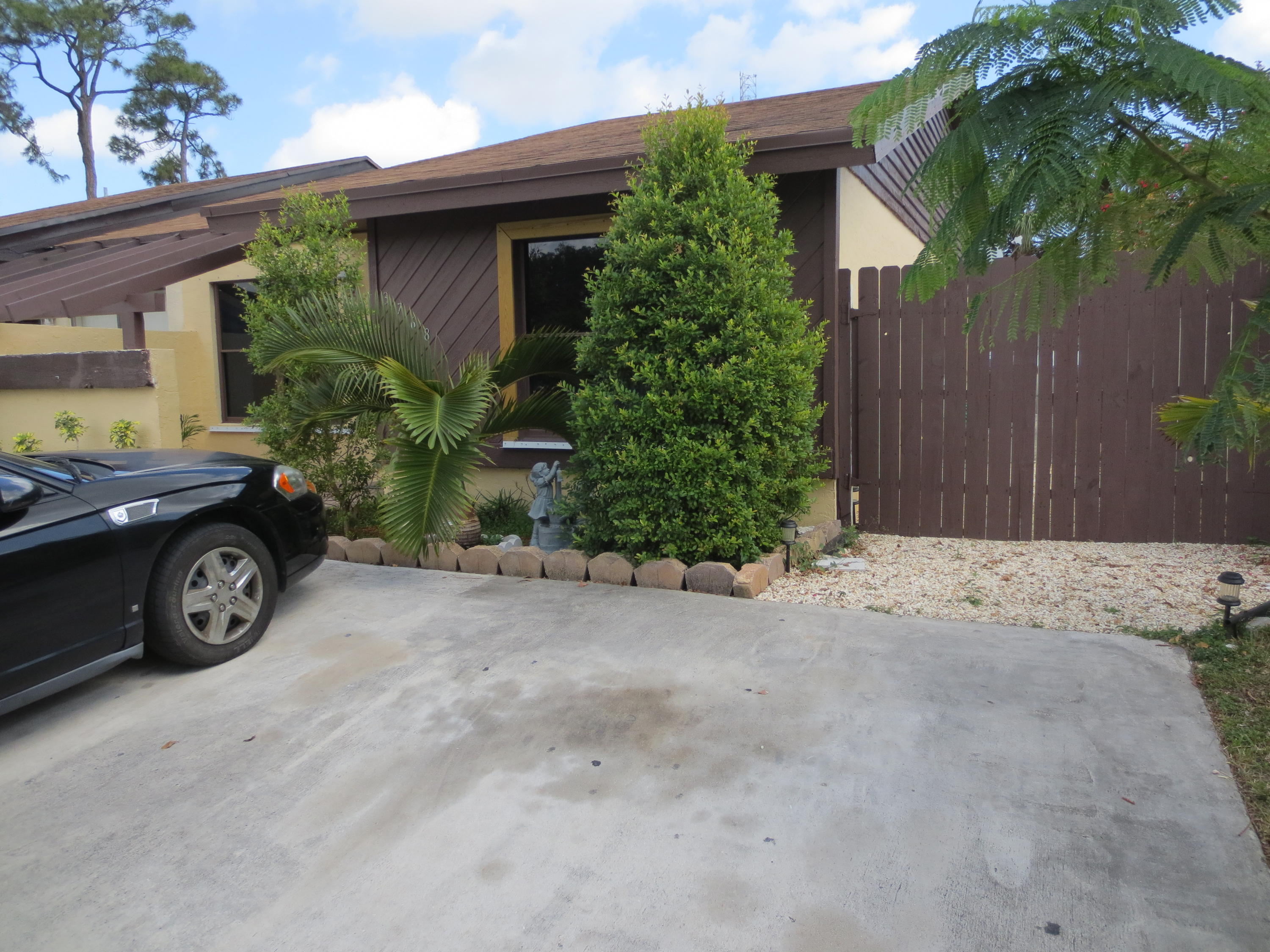 3768 Mil-Stream Court Greenacres, FL 33463 - Photo 34 of 36 a front view of a house with a garden