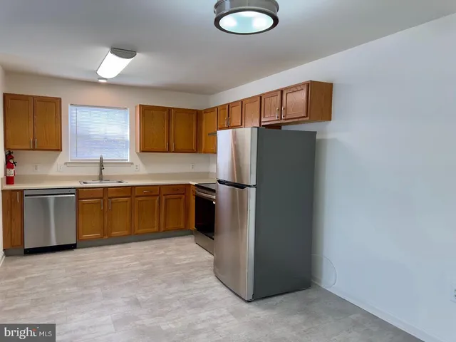 a kitchen with a refrigerator sink and cabinets