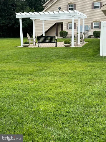 a view of a house with a big yard and large trees