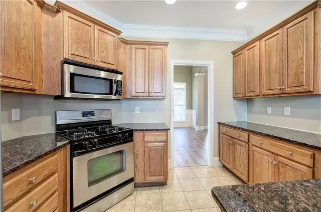 a kitchen with granite countertop wooden cabinets and a stove top oven