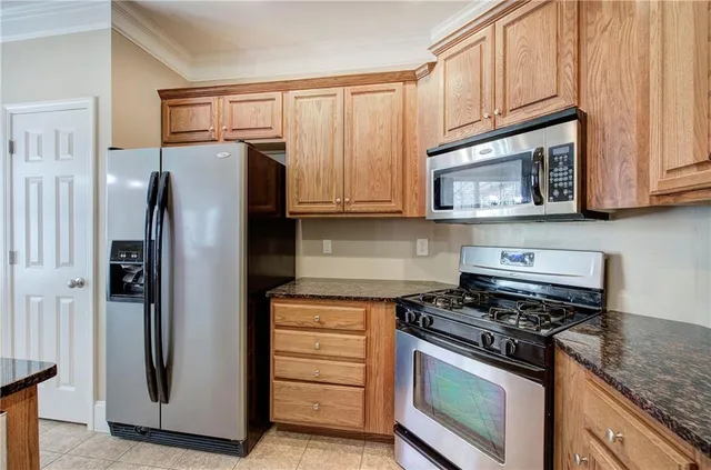 a kitchen with stainless steel appliances granite countertop a refrigerator stove and cabinets