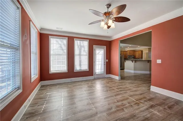 a view of an empty room with a window and a kitchen