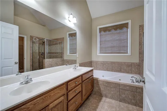 a bathroom with a tub double vanity sink and mirror