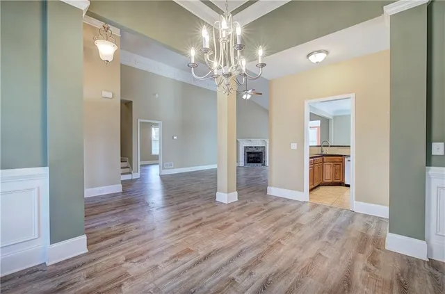 a view of a hallway with wooden floor and a kitchen