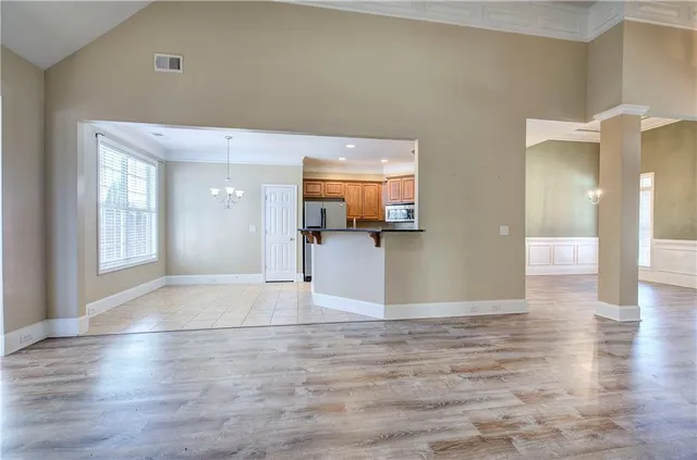 a view of a livingroom with wooden floor and a kitchen