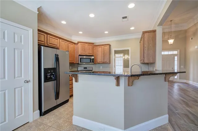 a kitchen with stainless steel appliances granite countertop a refrigerator and a stove