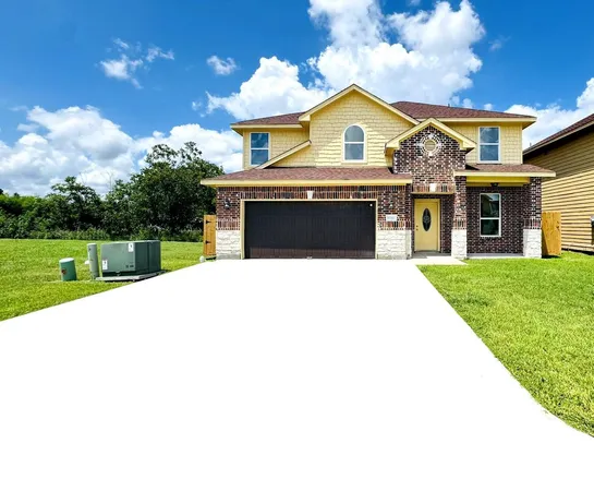a view of a house with a yard and a large tree
