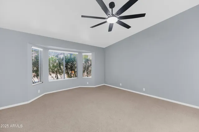an empty room with a window and a fan
