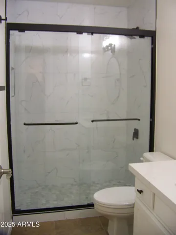 a white toilet sitting next to a shower